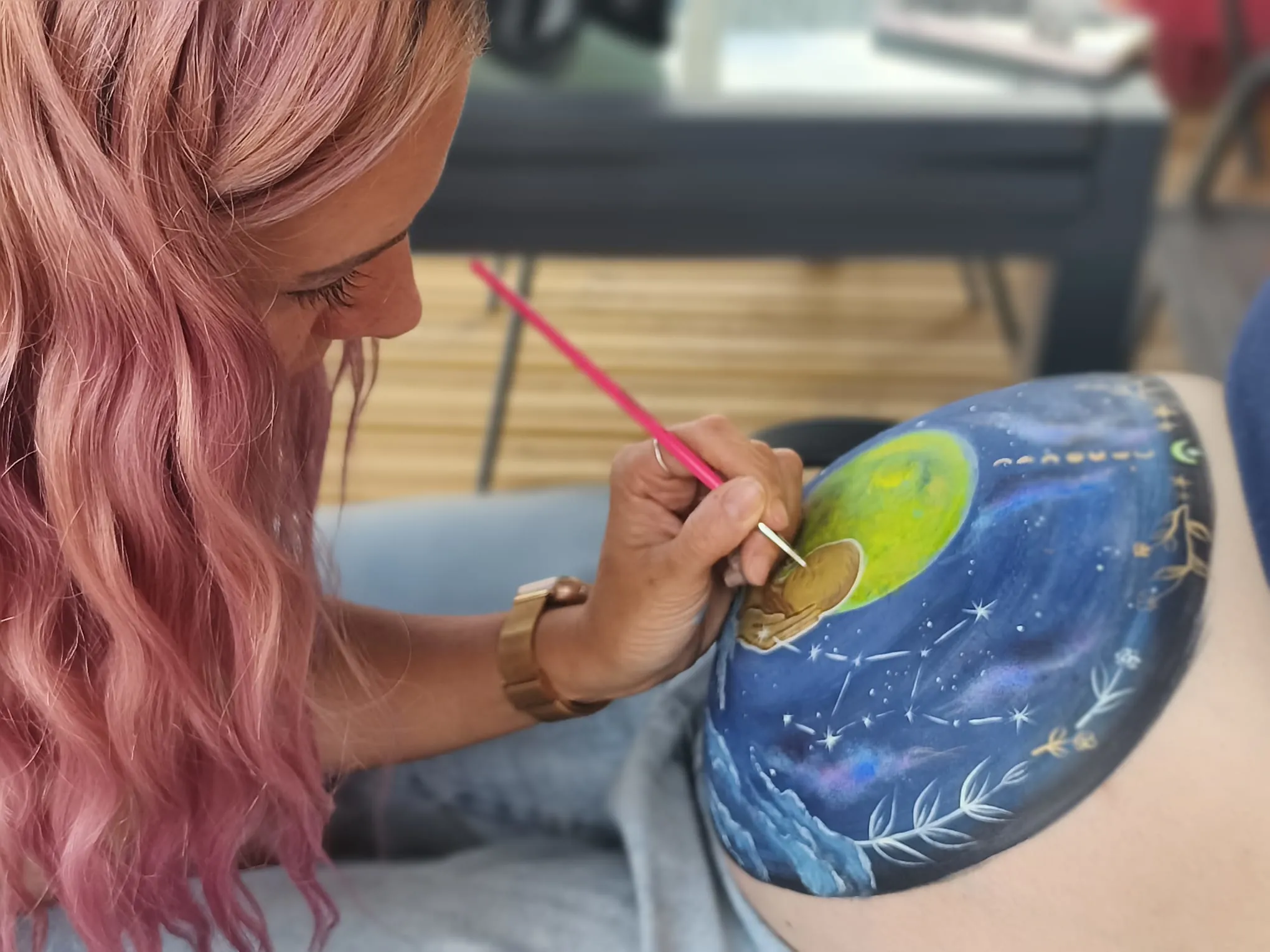 R&eacute;alisation d&rsquo;un belly painting au pinceau sur le ventre d&rsquo;une future maman